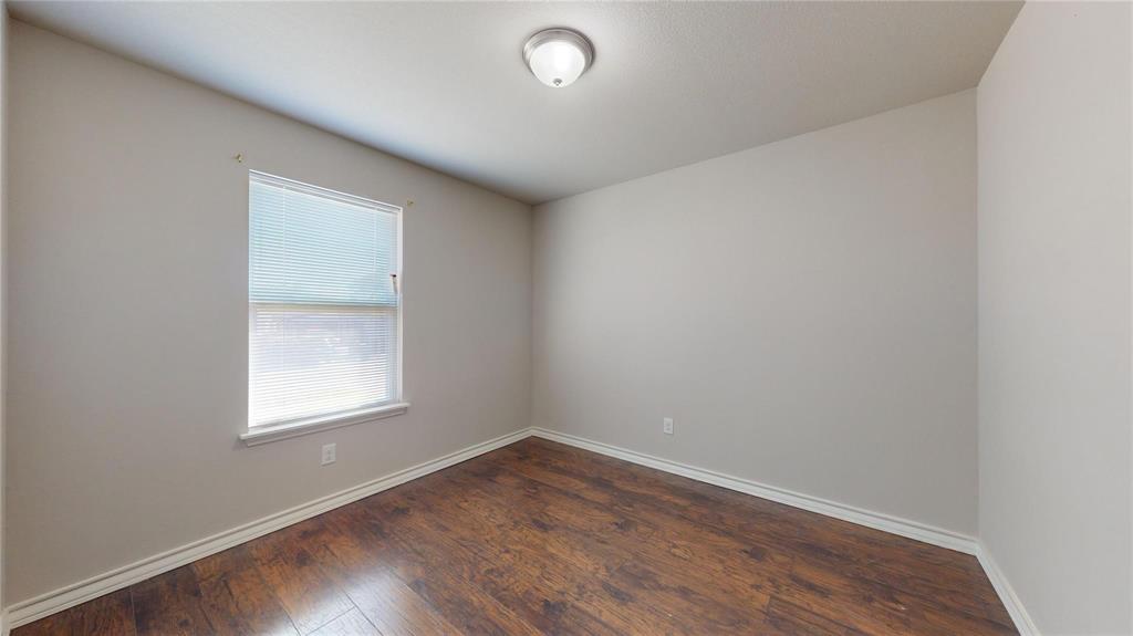2104 Daniel Street Fort Worth, TX 76104 - Photo 8 of 12 Empty room featuring dark wood finished floors and baseboards