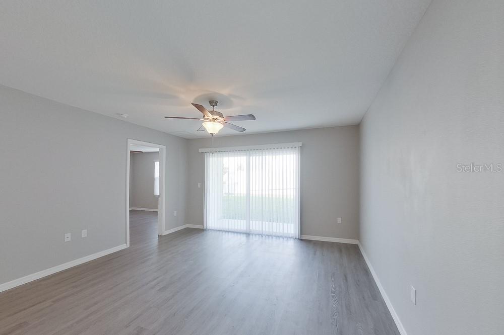 8656 Southwest 44th Court Ocala, FL 34476 - Photo 5 of 19 an empty room with wooden floor and windows
