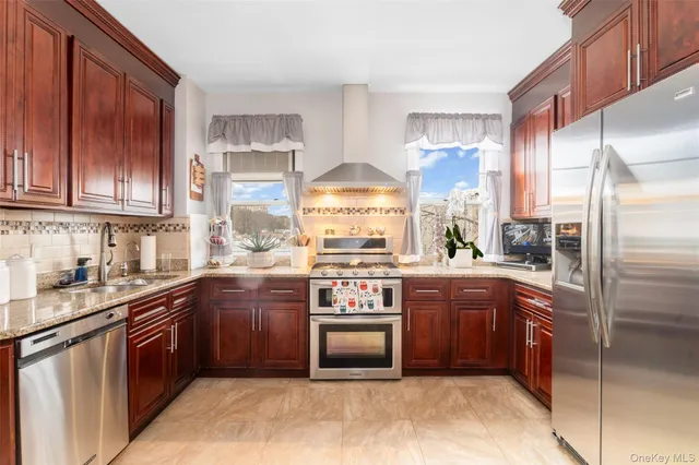 a kitchen with stainless steel appliances granite countertop a stove a sink and a refrigerator
