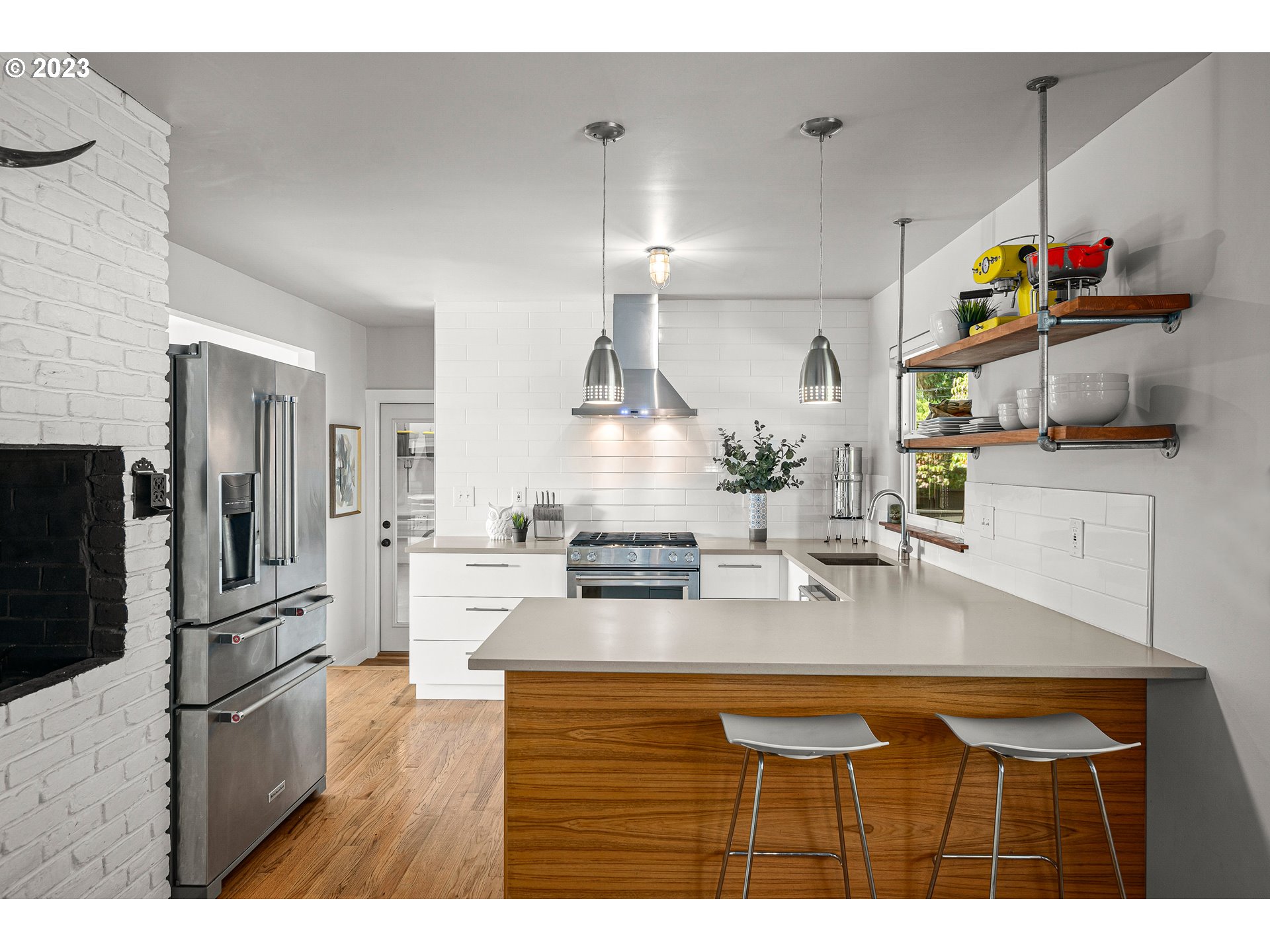 5914 Southwest Gunther Lane Portland, OR 97219 - Photo 11 of 40 a kitchen with kitchen island granite countertop stainless steel appliances lots of counter top space cabinets and wooden floor