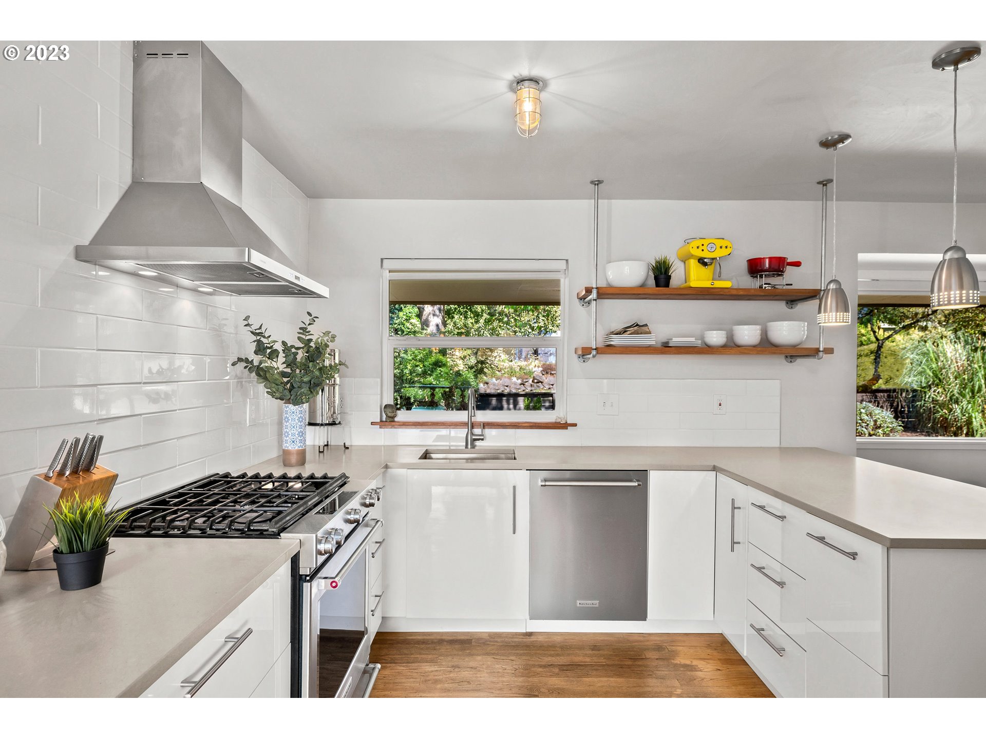 5914 Southwest Gunther Lane Portland, OR 97219 - Photo 13 of 40 a kitchen with stainless steel appliances a stove a chimney a sink and cabinets
