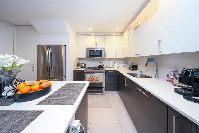 a kitchen with stainless steel appliances granite countertop a sink dishwasher a refrigerator and a stove