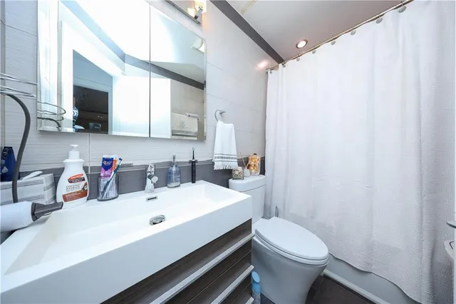 a bathroom with a sink a toilet and mirror