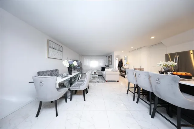 a living room with furniture a couch and a dining table with wooden floor