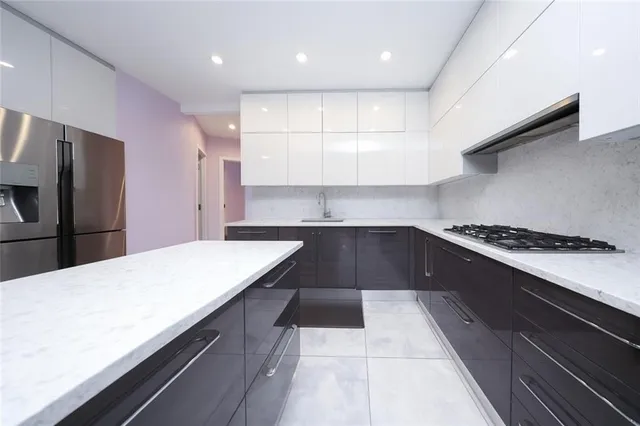 a kitchen with kitchen island a counter space a stove and a refrigerator