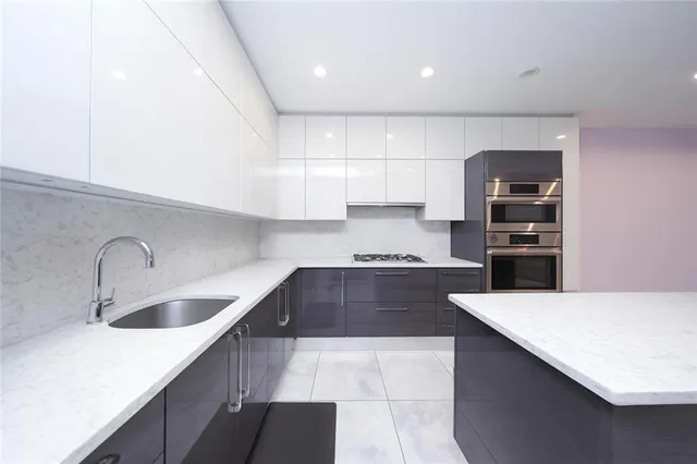 a kitchen with kitchen island a sink appliances and cabinets