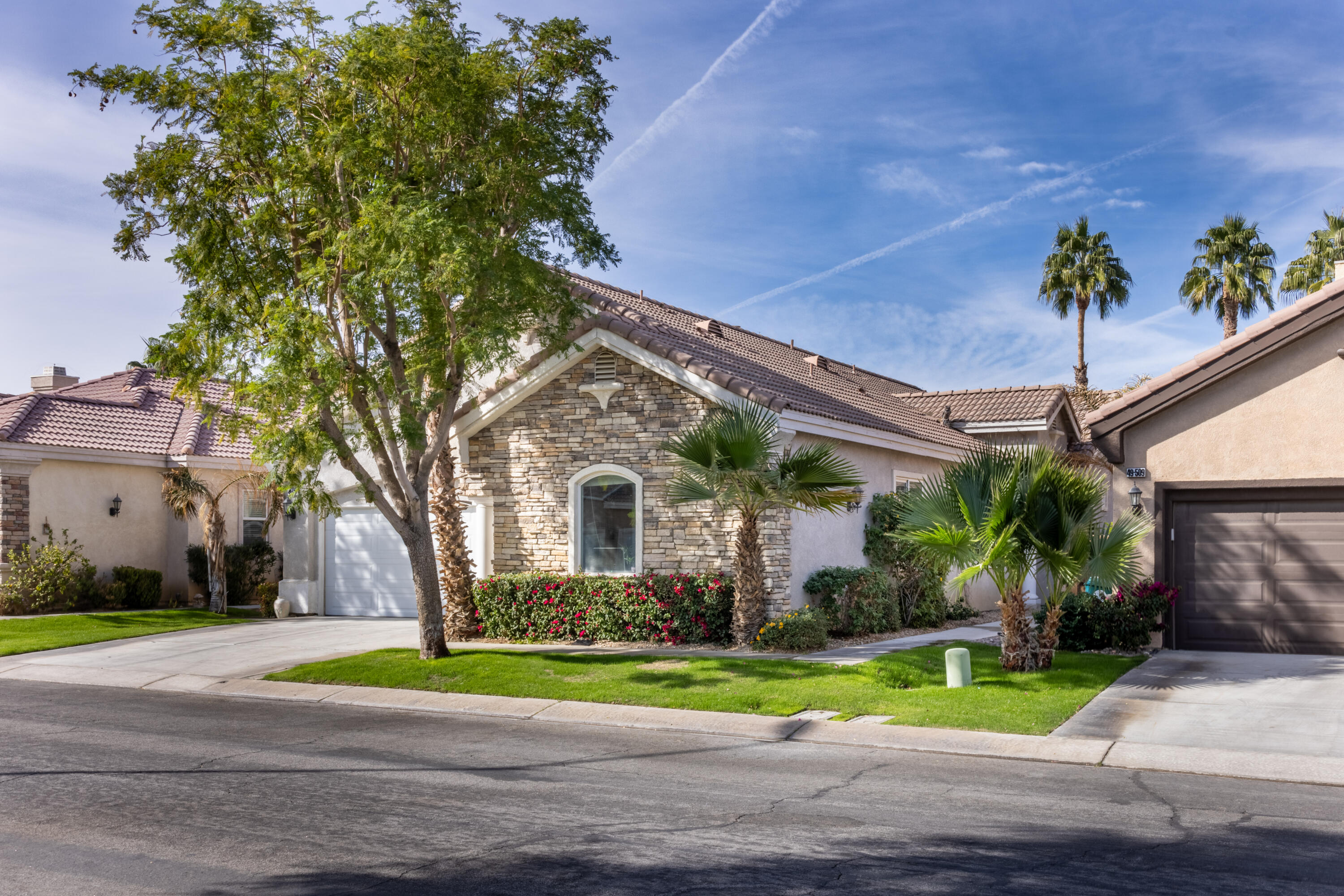 49527 Wayne Street Indio, CA 92201 - Photo 80 of 147 a front view of a house with a yard and potted plants