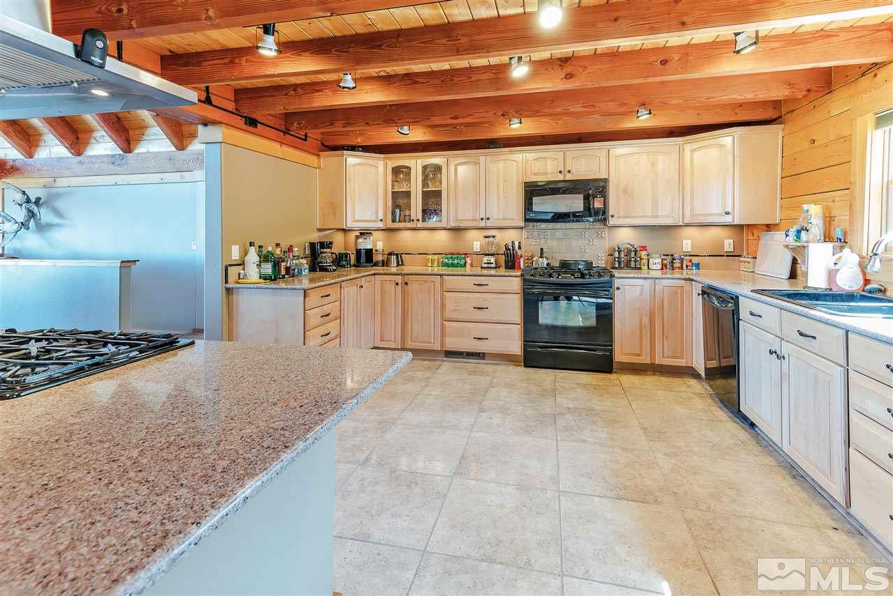 4820 Livery Road Reno, NV 89521 - Photo 7 of 25 a large kitchen with stainless steel appliances granite countertop a stove and a sink