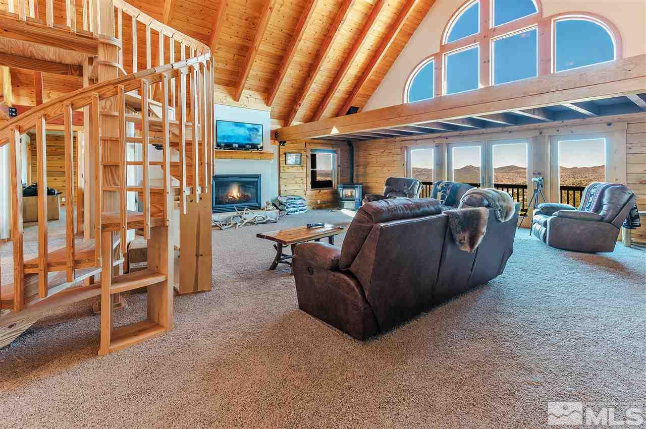 4820 Livery Road Reno, NV 89521 - Photo 9 of 25 a living room with furniture a fireplace and a ceiling fan