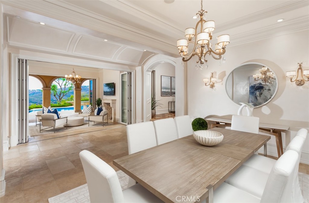 1 Shell Beach Newport Coast, CA 92657 - Photo 13 of 46 a view of a dining room with furniture a chandelier and wooden floor