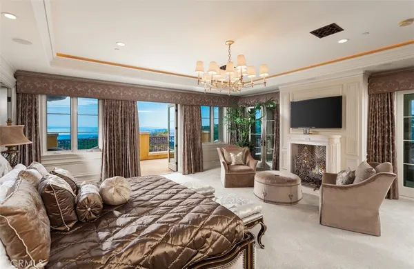 a bedroom with a bed a couches and a fireplace with the potted plants