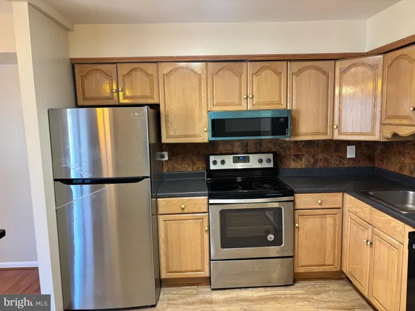 a kitchen with stainless steel appliances a refrigerator sink and cabinets