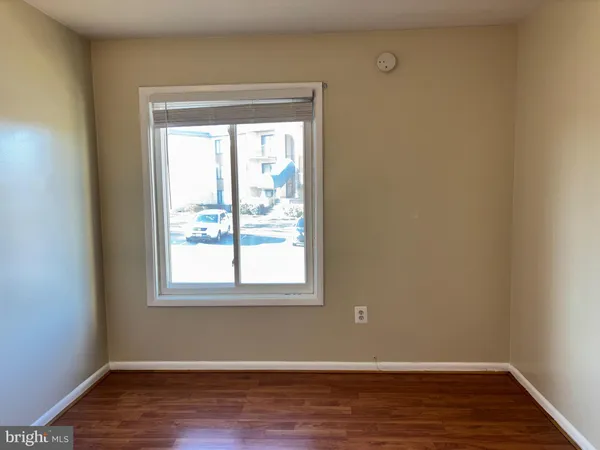 a view of a room with wooden floor and a window