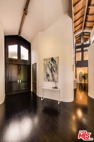 a view of a room with wooden floor furniture and windows