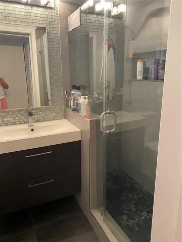 a bathroom with a sink a mirror and shower