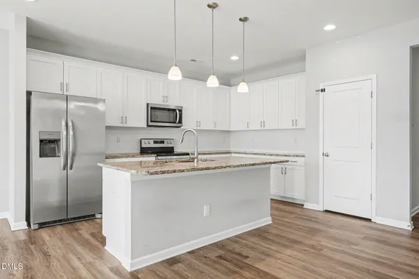 a kitchen with kitchen island a sink stainless steel appliances and cabinets