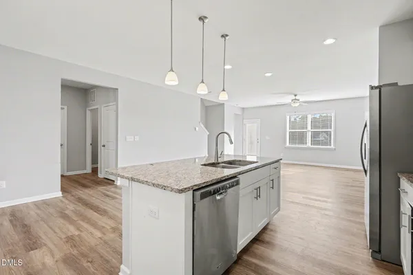 a kitchen with stainless steel appliances granite countertop a sink a refrigerator and a window