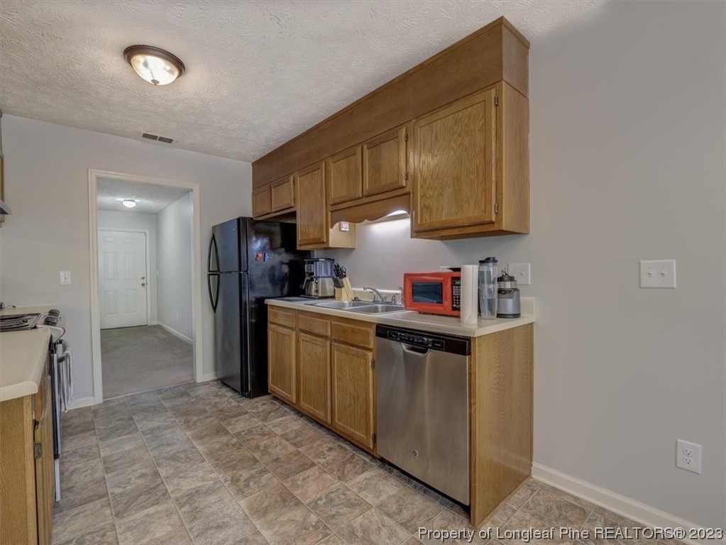 433 Wapiti Drive Spring Lake, NC 28390 - Photo 14 of 31 a kitchen with stainless steel appliances granite countertop a refrigerator a stove a sink and a microwave