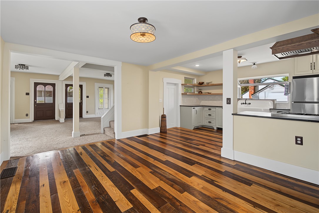 8707 Lytle Ferry Road Waynesville, OH 45068 - Photo 11 of 54 Warm wood flooring extends into a thoughtfully designed kitchen area, creating a welcoming and cohesive living space.