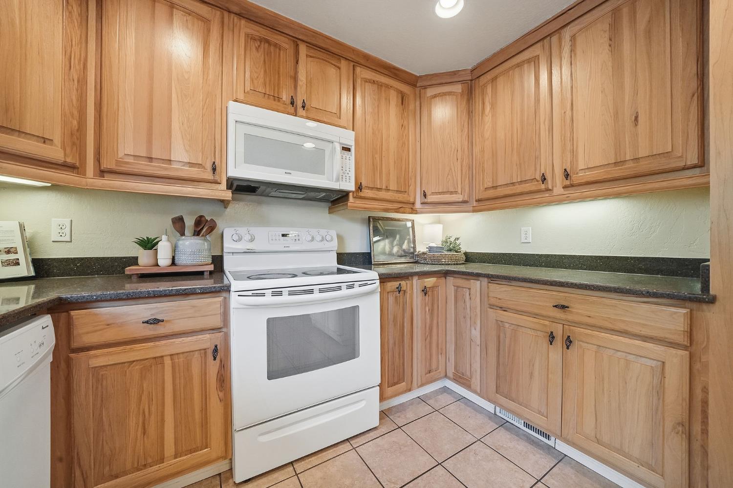 26019 Ridge Drive Pioneer, CA 95666 - Photo 20 of 75 a kitchen with granite countertop white cabinets and white appliances