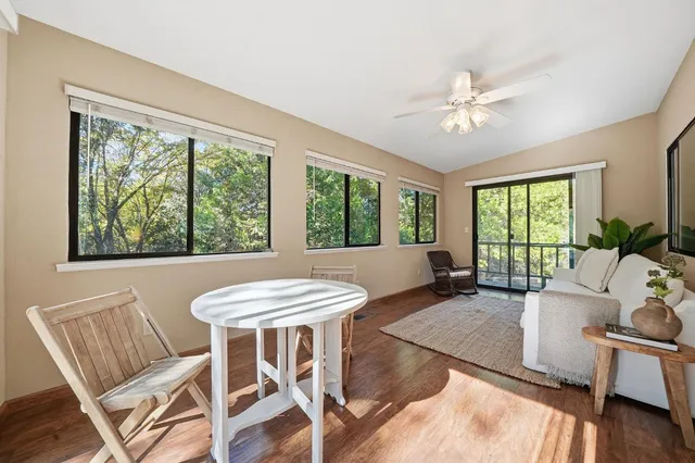 an empty room with a window and a ceiling fan