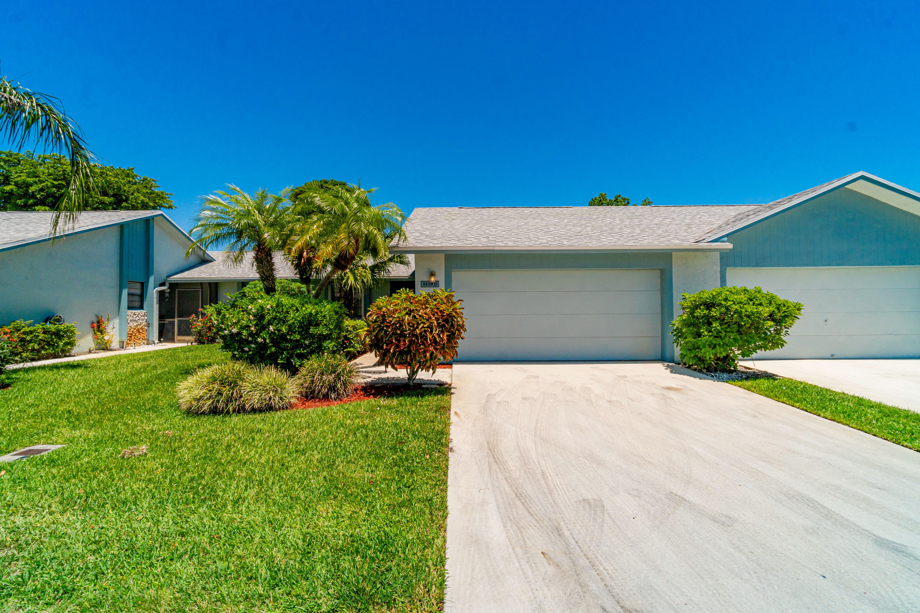 9159 Southwest 22nd Street, Unit D Boca Raton, FL 33428 - Photo 1 of 35 a front view of a house with a yard
