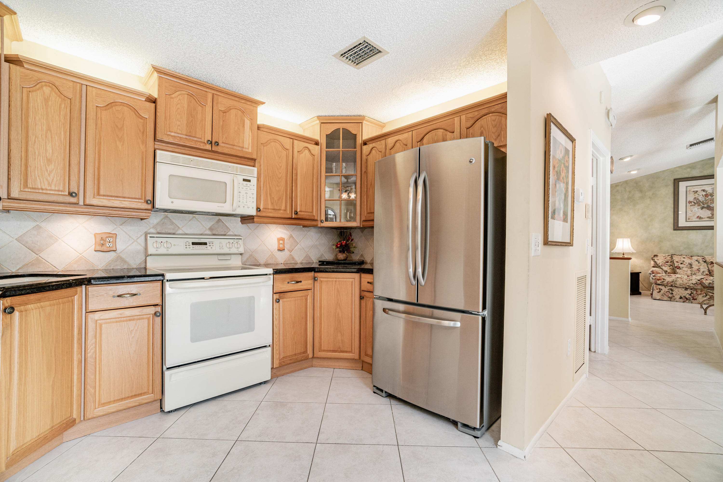 9159 Southwest 22nd Street, Unit D Boca Raton, FL 33428 - Photo 15 of 35 a kitchen with stainless steel appliances granite countertop a refrigerator sink and cabinets