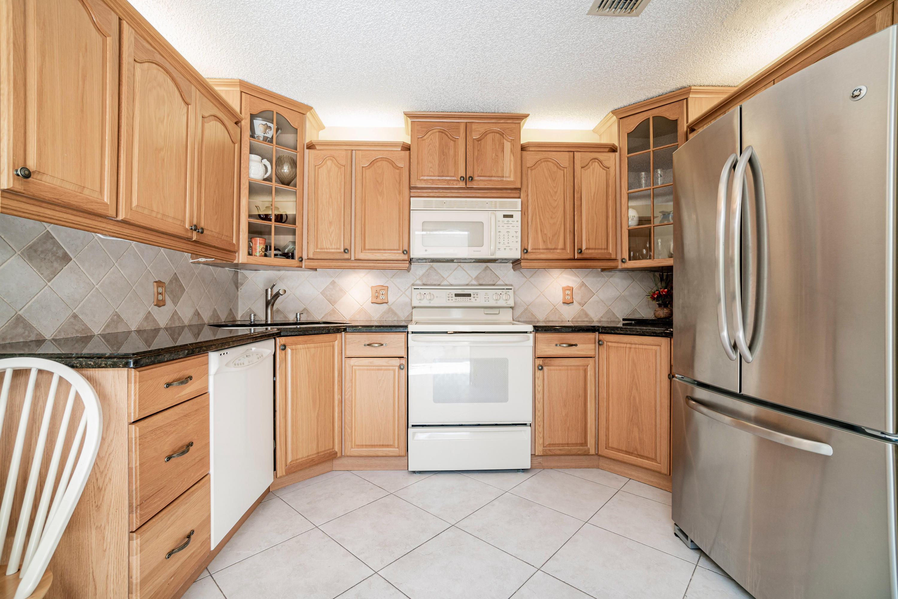 9159 Southwest 22nd Street, Unit D Boca Raton, FL 33428 - Photo 16 of 35 a kitchen with stainless steel appliances granite countertop a refrigerator sink and cabinets