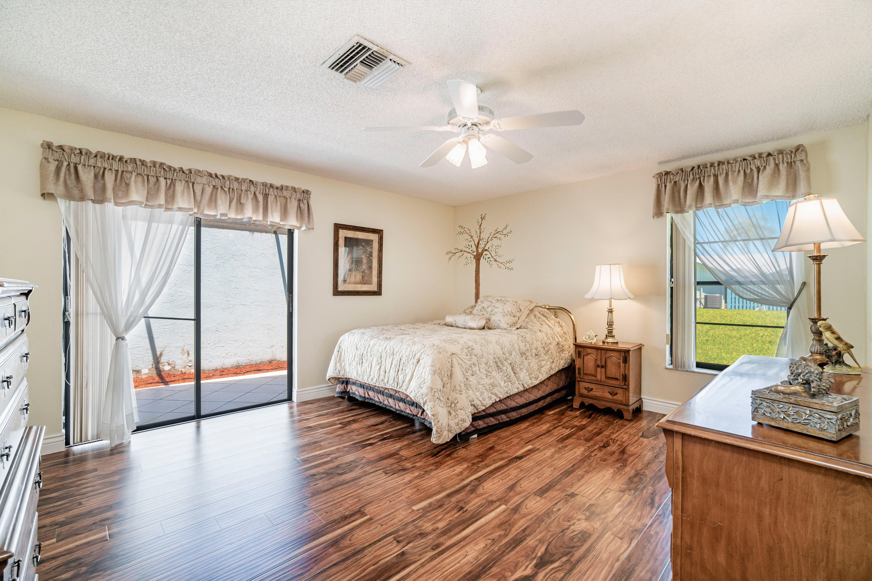 9159 Southwest 22nd Street, Unit D Boca Raton, FL 33428 - Photo 18 of 35 a bedroom with a large bed and a chandelier
