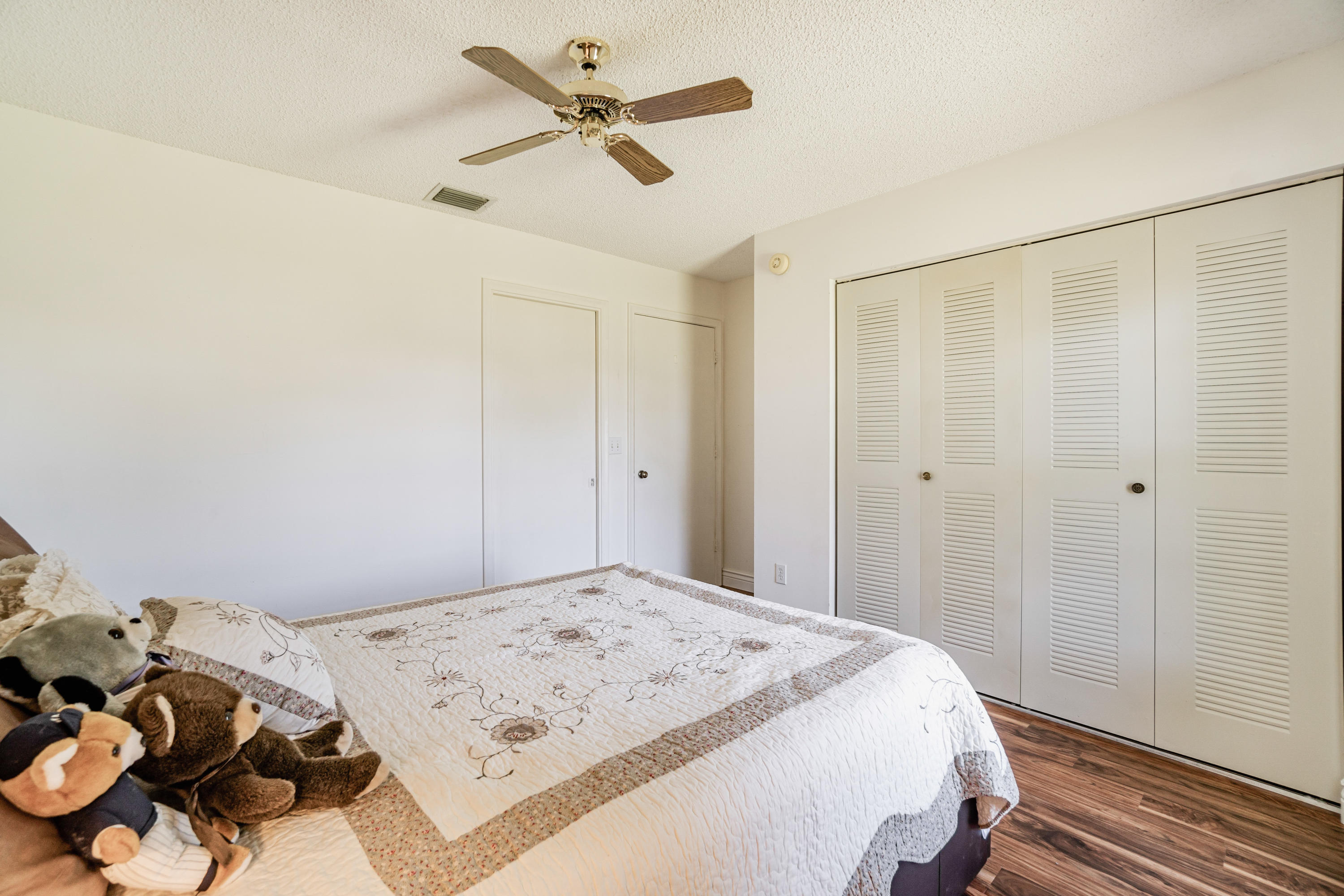9159 Southwest 22nd Street, Unit D Boca Raton, FL 33428 - Photo 23 of 35 a bedroom with a bed and a chandelier