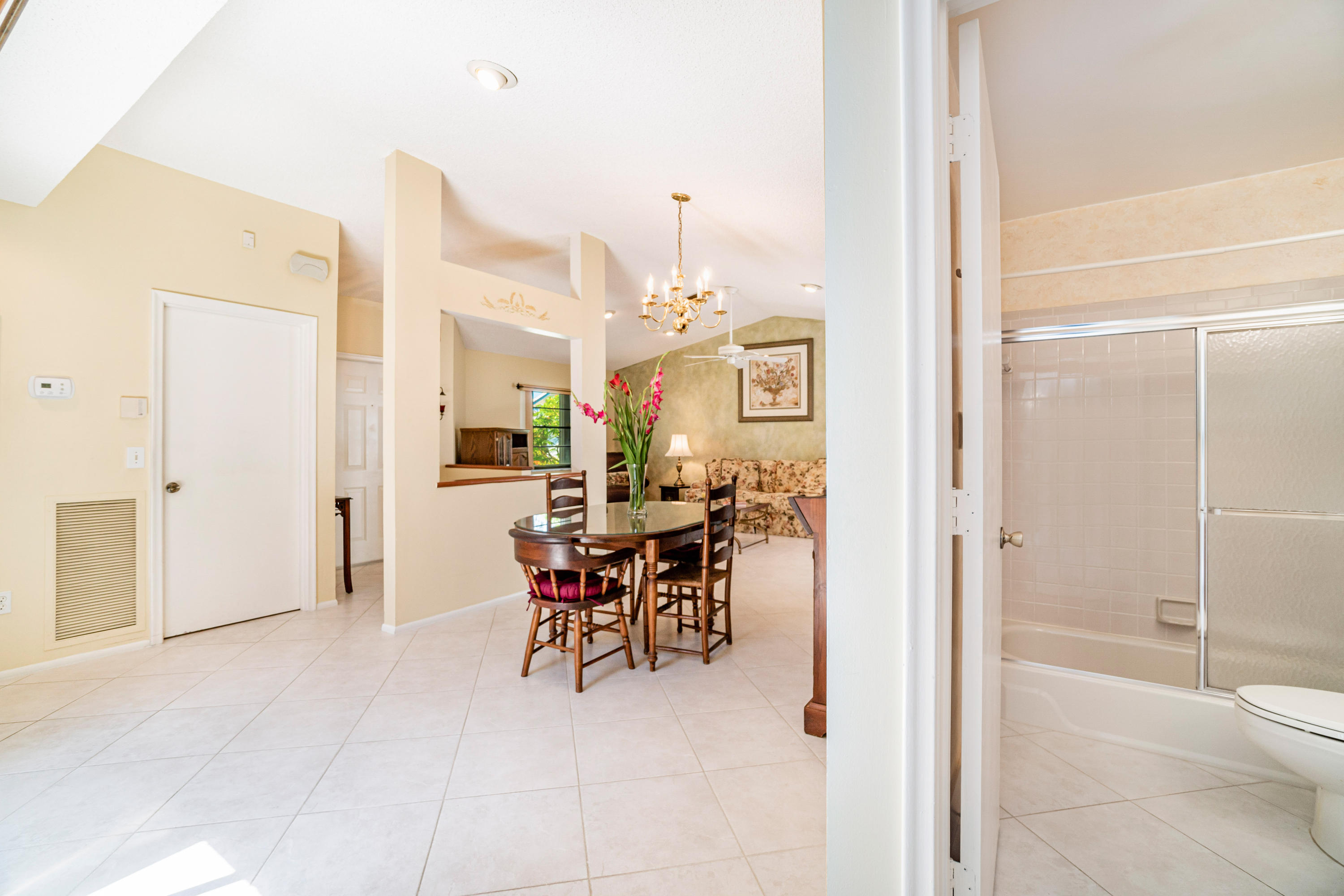 9159 Southwest 22nd Street, Unit D Boca Raton, FL 33428 - Photo 9 of 35 a dining room with furniture and a chandelier fan