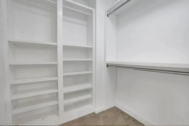 a view of walk in closet with empty racks