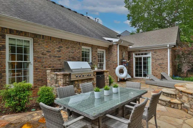 a backyard of a house with barbeque oven table and chairs