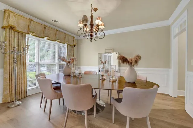 a dining room with furniture a chandelier and wooden floor
