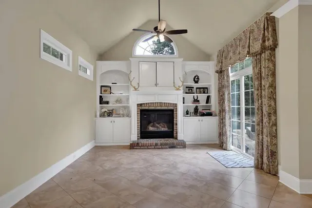 a view of an empty room with a fireplace and a window