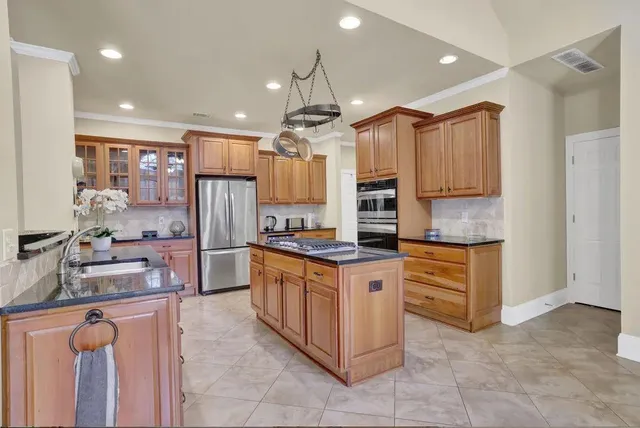 a kitchen with stainless steel appliances granite countertop a stove oven and a refrigerator