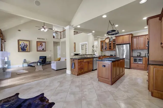 a large kitchen with stainless steel appliances lots of counter space and windows