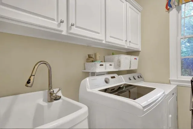 a view of a sink a stove and cabinets