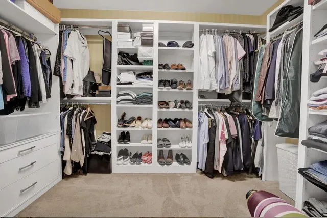 a view of walk in closet with clothes and shoes