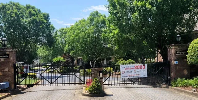 a sign board with a bench and trees around