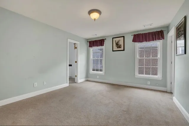 an empty room with windows and closet