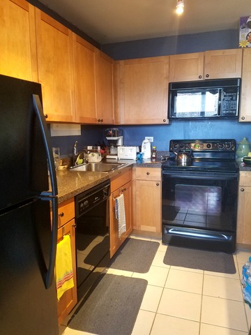 655 West Irving Park Road, Unit 1114 Chicago, IL 60613 - Photo 6 of 14 a kitchen with a stove and a refrigerator