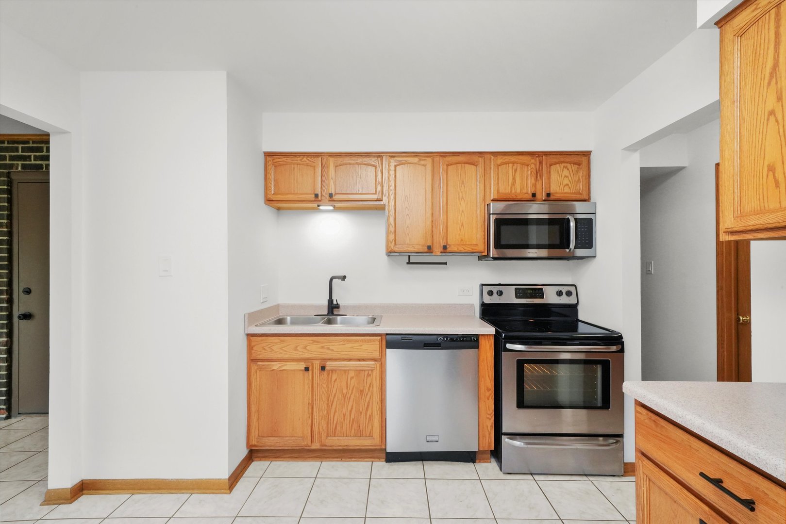 9016 West 140th Street, Unit 3A Orland Park, IL 60462 - Photo 11 of 25 a kitchen with stainless steel appliances a stove microwave and sink