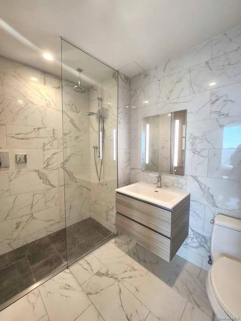 131-01 40 Road, Unit 19Z Queens, NY 11354 - Photo 6 of 9 a bathroom with a sink a toilet and shower