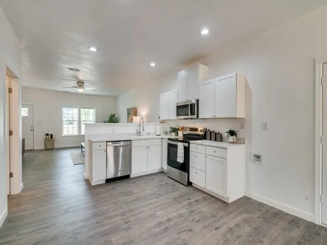 a kitchen with white cabinets and appliances