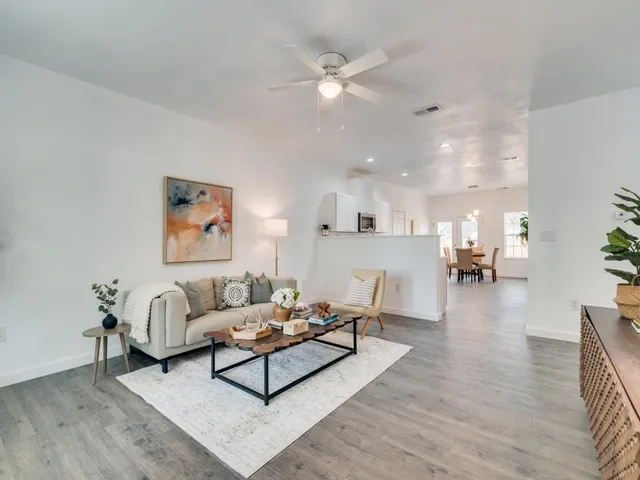 a living room with furniture and a wooden floor