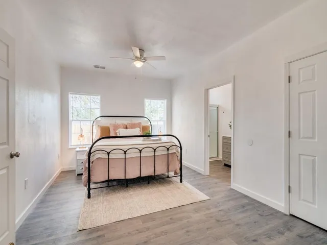 a bedroom with a large bed and a chandelier