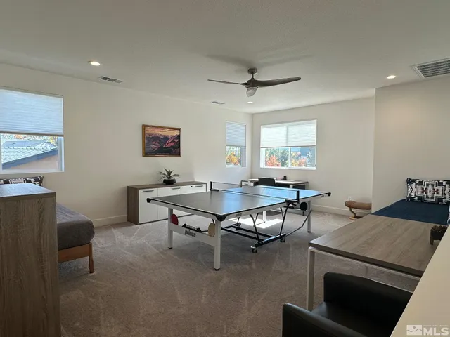 a living room with furniture a ceiling fan and a window