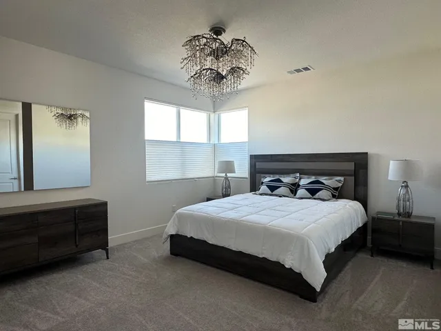 a bedroom with a bed and a chandelier