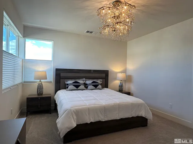 a bedroom with a bed and a chandelier